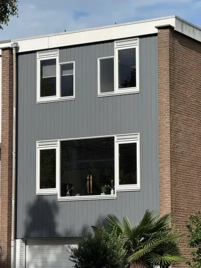 Woning met afgeronde grijze Keralit-gevelbekleding, verticaal gemonteerd