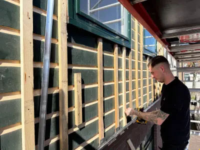 Bestaande geschilderde houten gevel met nieuw regelwerk ervoor