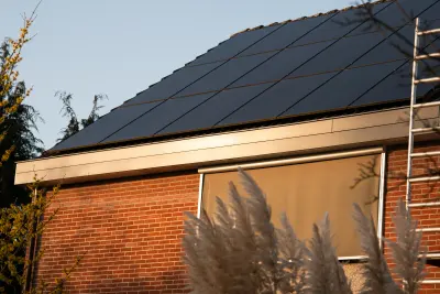 Woning met rode baksteen en zonnepanelen waar een nieuwe gevel op komt