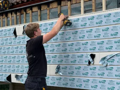 Monteur bevestigt dampopen folie op de voorbereide onderconstructie