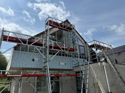 Woning met steigers voor de gevelrenovatie, met het te vervangen gevelvlak en de bereikbaarheid in beeld