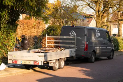 Bedrijfsbus en aanhanger van Top Gevelbekleding in de straat bij een project
